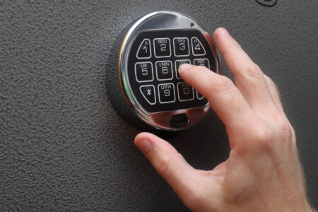Hand enters combination on digital lock on a safe